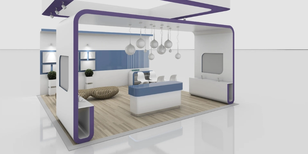 Modern Ve Minimal Fuar Stand Tasarımı &Ouml;rneği; Beyaz, Mavi Ve Mor Tonlarda Tasarlanmış A&ccedil;ık Konsept Stand Alanı, Ahşap Zemin, Modern Karşılama Bankosu, Sarkıt Aydınlatmalar Ve Ziyaret&ccedil;i Etkileşimine Uygun Ferah Sergi Alanı.